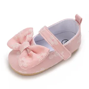 Nahaufnahme rosa Baby-Lauflernschuh mit Blumenmuster und großer dekorativer Schleife