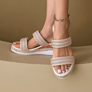 Dettaglio di sandali con zeppa da donna con cinturini in corda intrecciata e strass.
