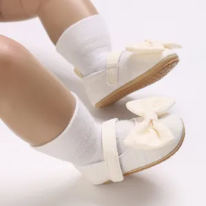 Nahaufnahme von weißen Lauflernschuhen für Mädchen mit einer eleganten Schleife