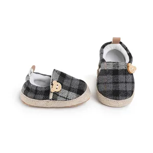 Detailed view of plaid baby walking shoes with cute bear buttons and soft soles.