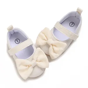 Detailansicht weißer Baby-Prinzessin-Lauflernschuhe mit großen Schleifen und weichen Sohlen.