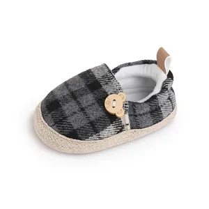 Primer plano de zapato de cuadros para bebés con un lindo detalle de botón de oso de madera