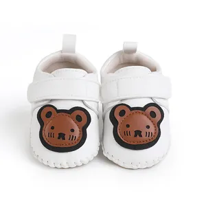 Vorderansicht weißer Baby-Lauflernschuhe mit süßem braunem Bären-Cartoon-Patch