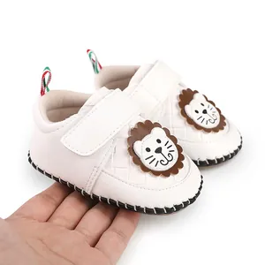 Detail of white baby walking shoes featuring a cartoon lion and Velcro strap