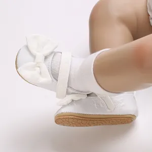 Detailansicht der weißen Baby-Prinzessinenschuhe mit Schleife und weichen Socken