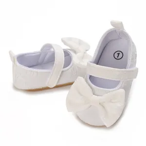 Nahaufnahme von weißen Lauflernschuhen für Mädchen mit Schleife und weicher Sohle.