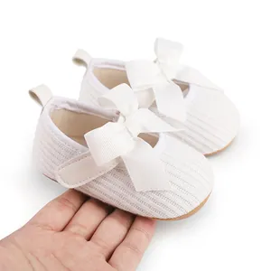 Vue détaillée de chaussures blanches nervurées pour bébé avec un grand nœud élégant