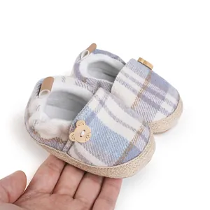 Detailed view of blue plaid baby walking shoes featuring cute wooden bear button accents.