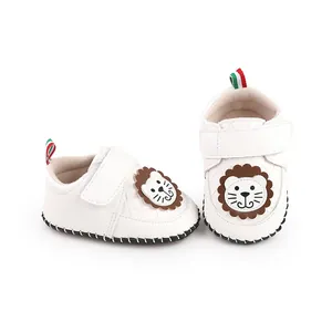 Close-up of white baby walker shoes with cartoon lion design and velcro straps