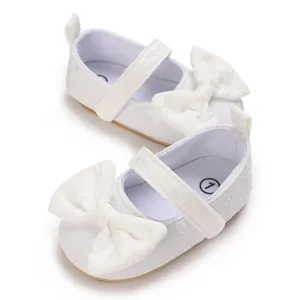 Detailansicht der eleganten weißen Baby-Mädchen-Schuhe mit großen Schleifenakzenten