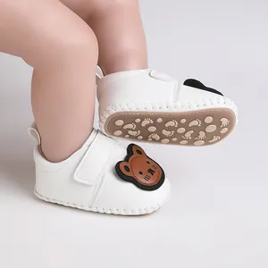 Detailansicht der weißen Baby-Lauflernschuhe mit Bären-Patch und rutschfester Sohle