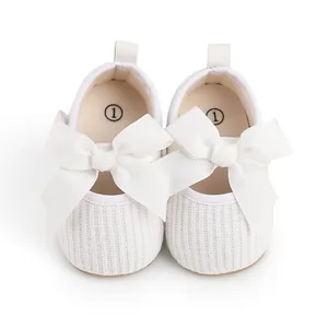 Vue détaillée des chaussures de marche blanches pour bébés avec de grands nœuds