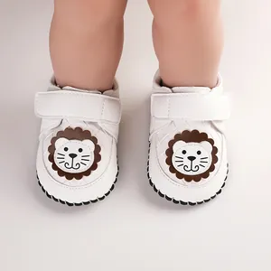 Detailed close-up of white baby walking shoes featuring a cute cartoon lion design