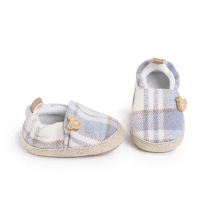 Close-up detail of British style plaid baby pre-walker shoes with a cute bear charm decoration