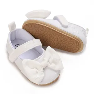 Detailansicht der weißen Lauflernschuhe für Babys mit weicher Sohle und großer Schleife.