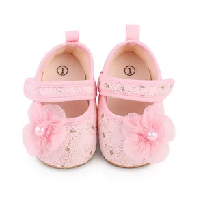 Nahaufnahme von rosa Baby-Prinzessinenschuhen mit zarter Spitze und großer Stoffblume