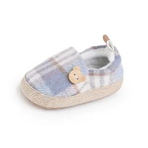 Detalle de zapato de bebé a cuadros con un lindo botón de oso de madera.