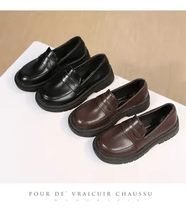 Detailed view of classic black and dark brown British style girls' loafers on a platform