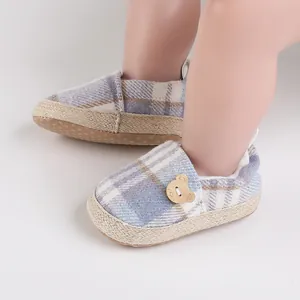 Primer plano de zapatos de bebé a cuadros con una adorable decoración de botón de oso