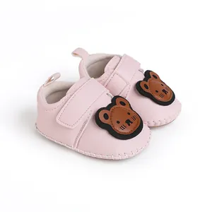 Detailansicht der rosa Baby-Lauflernschuhe mit süßem braunem Zeichentrickbär-Aufnäher