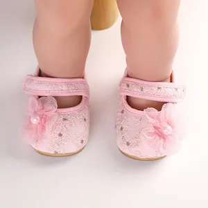 Nahaufnahme von rosa Baby-Prinzessin-Schuhen mit Spitzenblumen und Perlenverzierung.