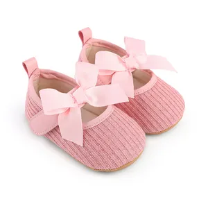 Détail macro de chaussures de cérémonie roses pour bébé avec un grand nœud en ruban