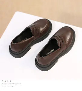 Detailed view of brown girls' British style loafers with thick black soles