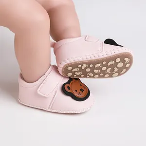 Detail von rosa Baby-Lernlaufschuhen mit Bären-Motiv und rutschfester Sohle.