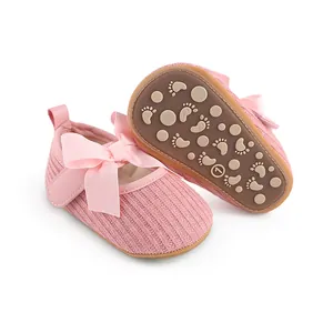 Gros plan de chaussures de bébé roses tricotées avec nœud et semelle antidérapante