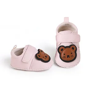 Detailansicht der rosa Cartoon-Lauflernschuhe für Babys mit süßem Bären-Aufnäher
