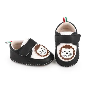 Close-up of black and white baby shoes with lion cartoon and velcro strap