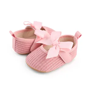 Vue détaillée de chaussures pour bébé fille en tricot rose avec un grand nœud élégant