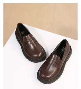 Close-up detail showing the texture and design of dark brown British style loafers for girls.