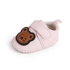 Detailansicht niedlicher rosa Baby-Lauflernschuhe mit Comic-Bär und praktischem Klettverschluss.