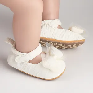 Vue détaillée des chaussures de marche blanches pour bébés avec nœud décoratif en mesh.