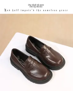 Detailed view of brown British style children's leather loafers with polished finish