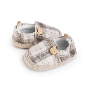 Zapatos de bebé a cuadros con un lindo botón de oso de madera, vista de detalle