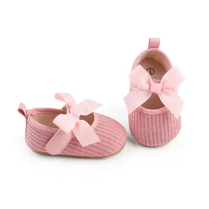Vue détaillée de chaussures roses pour bébé fille avec grand nœud côtelé et semelle souple
