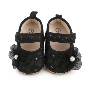 Makro-Detail von schwarzen Spitzen-Babyschuhen mit elegantem Blumenperlendekor