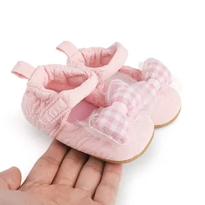 Détail de chaussures de marche roses pour bébé avec nœud à carreaux pour comparer la taille