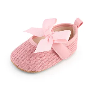Gros plan d'une chaussure rose pour bébé fille avec un grand nœud côtelé détaillé