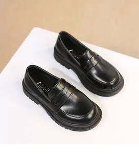 Macro view of black girls' leather loafers shoes featuring an elegant British school style