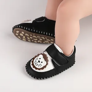 Detail of baby walking shoes with cute lion patch and non-slip paw print sole