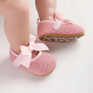Vue détaillée de chaussures roses pour bébé fille avec un grand nœud et texture en tricot