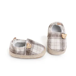 Detail view of plaid baby walking shoes featuring a cute wooden bear button and soft sole