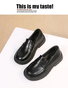 Detailed view of girls' black leather loafers featuring a classic British school style
