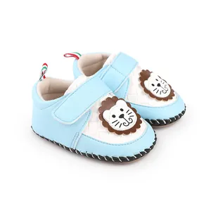 Close-up detail of light blue baby walking shoes featuring a cute cartoon lion design