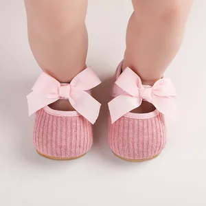 Gros plan de chaussures roses pour bébé fille avec détails de gros nœuds en ruban