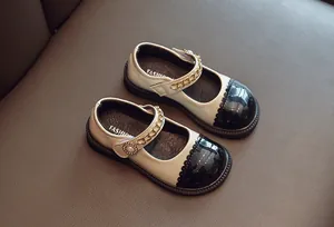 Detailansicht beige Mädchen-Mary-Janes mit schwarzer Kappe und goldener Kette