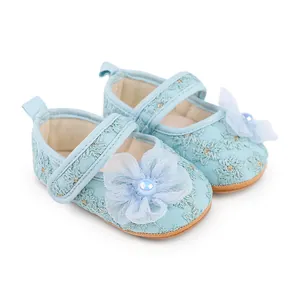 Nahaufnahme hellblauer Baby-Prinzessin-Schuhe mit zarten Verzierungen aus Netzblumen
